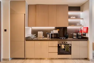 a kitchen with wooden cabinets and a counter top at FAM Living Dubai Escape Sleek Studio at Peninsula Five in Dubai