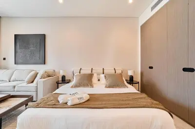 a bedroom with a large bed and a couch at FAM Living Dubai Escape Sleek Studio at Peninsula Five in Dubai