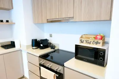 a kitchen with a stove and a microwave at 2-Bed Apartment with Infinity Pool in Dubai