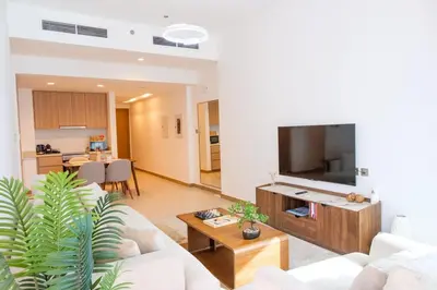a living room with a couch and a flat screen tv at 2-Bed Apartment with Infinity Pool in Dubai