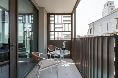 a balcony with a table and chairs on it at GuestReady - Coastal Style l 2Bed l Lagoon Escape in Dubai