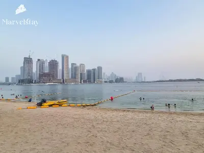 a group of people in the water at a beach at MarvelStay-Infinity Pool-Beachfront-The Palm in Dubai