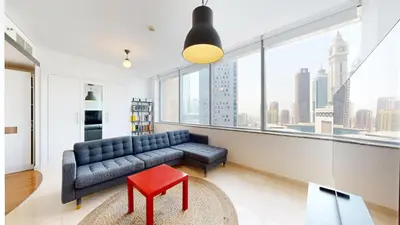 a living room with a couch and a red stool at Sky Gardens - High Rise Studio with Cityscape View in Dubai