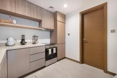 a kitchen with a wooden door and a stove at Moon Stays - 5 PAX Missoni Flat - Canal View in Dubai