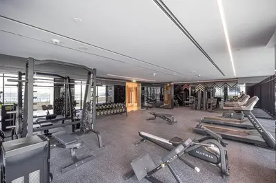 a gym with several treadmills and machines in it at Moon Stays - 5 PAX Missoni Flat - Canal View in Dubai