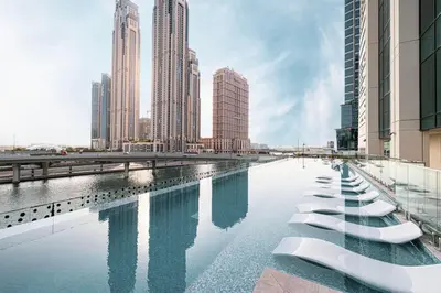 a swimming pool in a city with tall buildings at Moon Stays - 5 PAX Missoni Flat - Canal View in Dubai