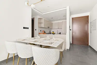 a kitchen and dining room with a table and chairs at VayK - Modern 2BR with Pool View in Sobha Hartland in Dubai