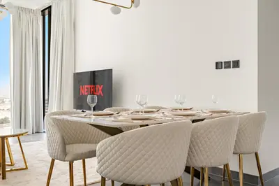 a dining room with a table and chairs at VayK - Modern 2BR with Pool View in Sobha Hartland in Dubai