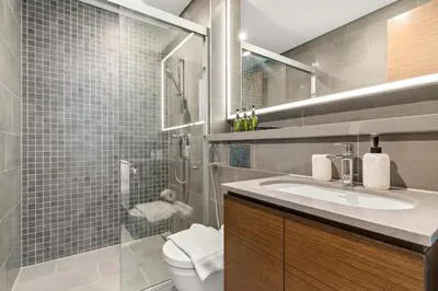 a bathroom with a shower and a toilet and a sink at VayK - Modern 2BR with Pool View in Sobha Hartland in Dubai