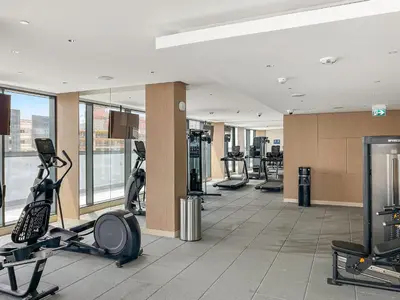 a gym with treadmills and ellipticals in a building at VayK - Modern 2BR with Pool View in Sobha Hartland in Dubai