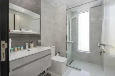 a bathroom with a shower and a toilet and a sink at Vogue Al Furjan Pearlz by Danube near Ibn Battuta Mall, Three Bedroom plus Kids room Apartment with Balcony and Private pool, Access to all Amenities, Walkable to Al Furjan Metro Station in Dubai