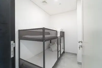 a black bunk bed in a room with a door at Vogue Al Furjan Pearlz by Danube near Ibn Battuta Mall, Three Bedroom plus Kids room Apartment with Balcony and Private pool, Access to all Amenities, Walkable to Al Furjan Metro Station in Dubai
