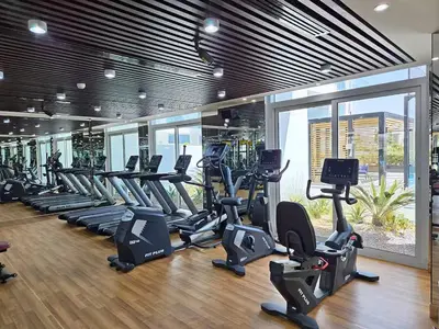 a gym with rows of treadmills and elliptical machines at Vogue Al Furjan Pearlz by Danube near Ibn Battuta Mall, Three Bedroom plus Kids room Apartment with Balcony and Private pool, Access to all Amenities, Walkable to Al Furjan Metro Station in Dubai