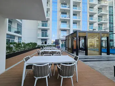 a patio with tables and chairs and a building at Vogue Al Furjan Pearlz by Danube near Ibn Battuta Mall, Three Bedroom plus Kids room Apartment with Balcony and Private pool, Access to all Amenities, Walkable to Al Furjan Metro Station in Dubai