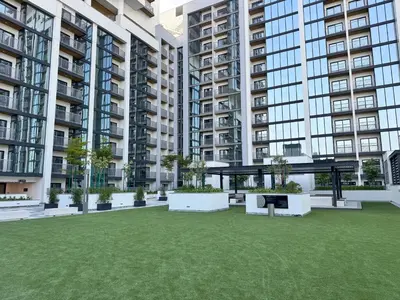 a courtyard in a building with a table and benches at Luxury 2BR in Sobha Hartland in Dubai