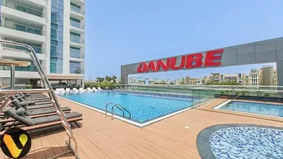 a large swimming pool on a building with a building at Vogue Al Furjan Pearlz by Danube near Ibn Battuta Mall, One Bedroom Apartment with Balcony and Pool View, Access to all Amenities, Walkable to Al Furjan Metro Station in Dubai