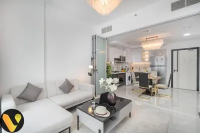 a living room with a white couch and a table at Vogue Al Furjan Pearlz by Danube near Ibn Battuta Mall, One Bedroom Apartment with Balcony and Pool View, Access to all Amenities, Walkable to Al Furjan Metro Station in Dubai