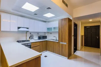a kitchen with white cabinets and a counter top at Modern and Spacious 2BR in Glamz, Al Furjan in Dubai