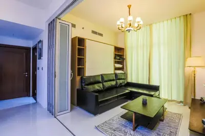 a living room with a black couch and a table at Modern and Spacious 2BR in Glamz, Al Furjan in Dubai