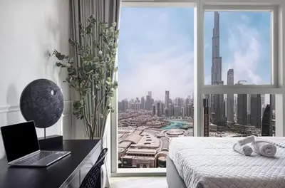 a bedroom with a laptop on a desk next to a window at Premium Suite 3 BR 200 degree Views 85-inch TV and Sunset View in Dubai