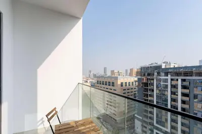 a chair sitting on a glass railing in a building at TRPS - Alef Noon, JVC - Brand New - Luxury Furnished 1BR - Prime JVC Location in Dubai