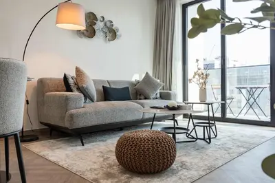 a living room with a couch and a table at TRPS - Alef Noon, JVC - Brand New - Luxury Furnished 1BR - Prime JVC Location in Dubai