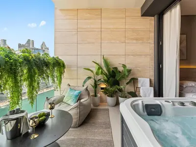 a bath tub in a room with a large window at BLVD - Stylish Stay with Private Jacuzzi and Canal View in Dubai