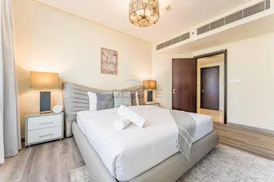 a bedroom with a large white bed and a chandelier at Close to Museum of the Future with Zaabeel Palace Views, Minutes from Dubai Mall And Burj Khalifa - Sky Gardens, DIFC by Deluxe Holiday Homes in Dubai