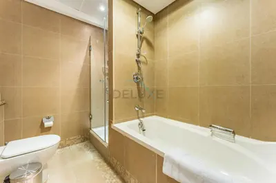 a bathroom with a tub and a toilet and a sink at Close to Museum of the Future with Zaabeel Palace Views, Minutes from Dubai Mall And Burj Khalifa - Sky Gardens, DIFC by Deluxe Holiday Homes in Dubai