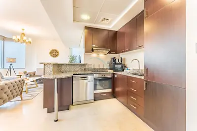 a kitchen with wooden cabinets and a counter top at Close to Museum of the Future with Zaabeel Palace Views, Minutes from Dubai Mall And Burj Khalifa - Sky Gardens, DIFC by Deluxe Holiday Homes in Dubai