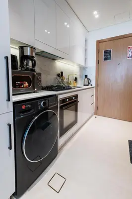 a kitchen with a stove and a dishwasher at Studio JVC I Fully Furnished I Epic Pool in Dubai
