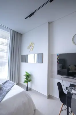 a bedroom with a bed and a desk and a computer at Studio JVC I Fully Furnished I Epic Pool in Dubai
