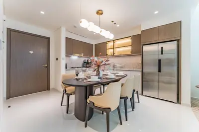 a kitchen and dining room with a table and chairs at Partial Sea Views with Private Beach Access, Near Dubai Marina and Palm Jumeirah, Grand Bleu Tower by Elie Saab, Tower 2, Emaar Beachfront by Deluxe Holiday Homes in Dubai