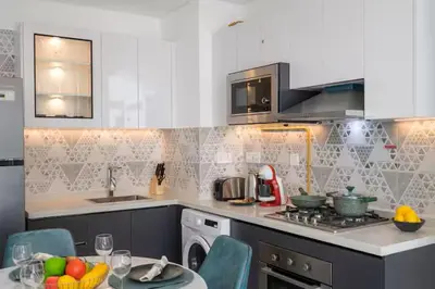 a kitchen with a stove top oven next to a sink at Vogue Al Furjan Pearlz by Danube near Ibn Battuta Mall, One Bedroom Apartment with Terrace and vibrant community view, Access to all Amenities, Walkable to Al Furjan Metro Station in Dubai