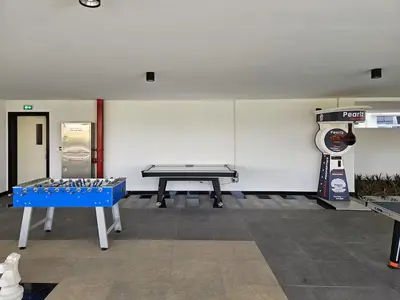 a room with a ping pong table in the middle at Vogue Al Furjan Pearlz by Danube near Ibn Battuta Mall, One Bedroom Apartment with Terrace and vibrant community view, Access to all Amenities, Walkable to Al Furjan Metro Station in Dubai