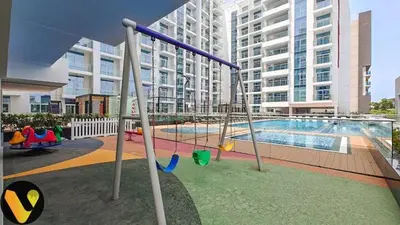 a playground in front of a large apartment building at Vogue Al Furjan Pearlz by Danube near Ibn Battuta Mall, One Bedroom Apartment with Terrace and vibrant community view, Access to all Amenities, Walkable to Al Furjan Metro Station in Dubai