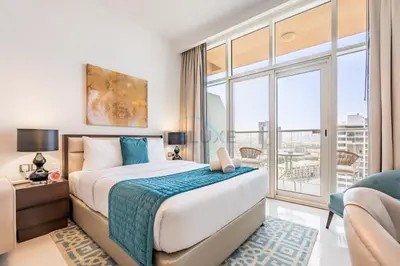 a bedroom with a bed and a large window at Studio Overlooking the Pool, Close to Parks, Grocery Stores, and Circle Mall, Damac Ghalia, JVC by Deluxe Holiday Homes in Dubai