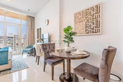 a dining room with a table and chairs at Studio Overlooking the Pool, Close to Parks, Grocery Stores, and Circle Mall, Damac Ghalia, JVC by Deluxe Holiday Homes in Dubai
