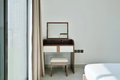 a dressing table with a mirror and a chair at Stylish 1BR Retreat Huge Balcony in Dubai