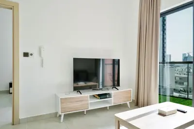 a living room with a tv and a table at Stylish 1BR Retreat Huge Balcony in Dubai