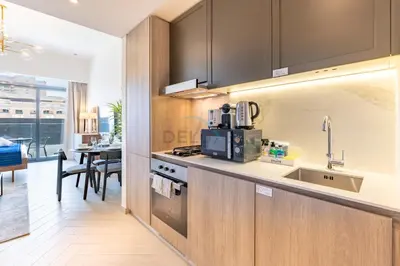 a kitchen with a sink and a counter top at Cozy Studio with Peaceful Community Views, Just Steps from Parks and Circle Mall, Oxford 212, JVC by Deluxe Holiday Homes in Dubai