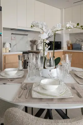 a table with plates and glasses and flowers on it at Beach Please in Dubai