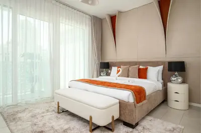 a bedroom with a large bed and a large window at Beach Please in Dubai