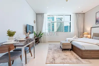 a bedroom with a bed and a desk and a desk at Walking Distance to Bay Avenue Mall, 5 Minutes Drive to Downtown Dubai, Close to Metro Station, With Canal View, The Cosmopolitan, Business Bay by Deluxe Holiday Homes in Dubai