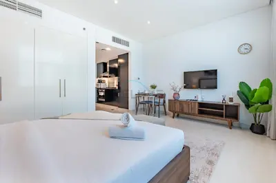 a bedroom with a bed and a living room at Walking Distance to Bay Avenue Mall, 5 Minutes Drive to Downtown Dubai, Close to Metro Station, With Canal View, The Cosmopolitan, Business Bay by Deluxe Holiday Homes in Dubai