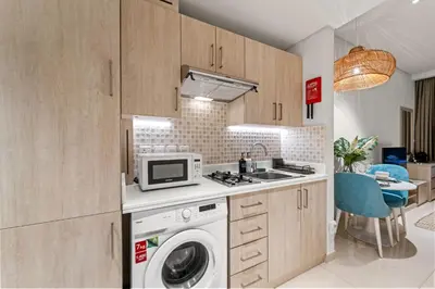 a kitchen with a washing machine and a microwave at Seven Palm Studio Roof Top Pool Beach Gym for free in Dubai