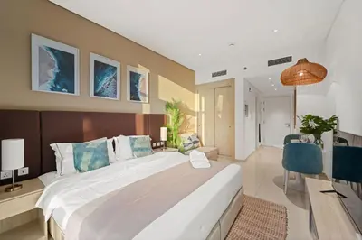 a bedroom with a large bed and a desk at Seven Palm Studio Roof Top Pool Beach Gym for free in Dubai