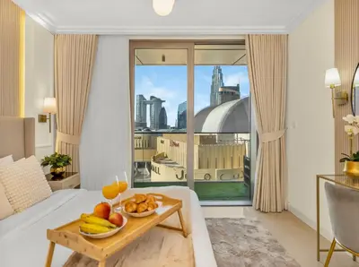 a room with a bed and a table with fruit on it at Kensington Perfect 1BR Burj View and Dubai Mall Link in Dubai