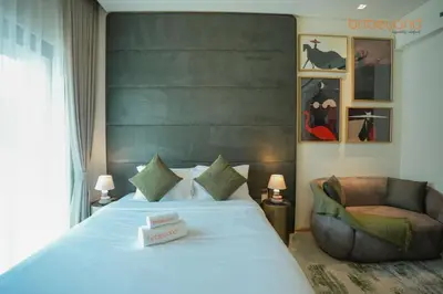 a bedroom with a large bed and a chair at The Autograph-Art Meets Comfort in Dubai