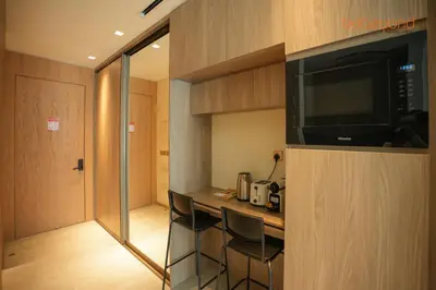 a small room with a bar with chairs and a microwave at The Autograph-Art Meets Comfort in Dubai